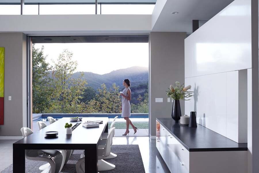 A woman looks at the landscape from the terrace in her luxury smart home.