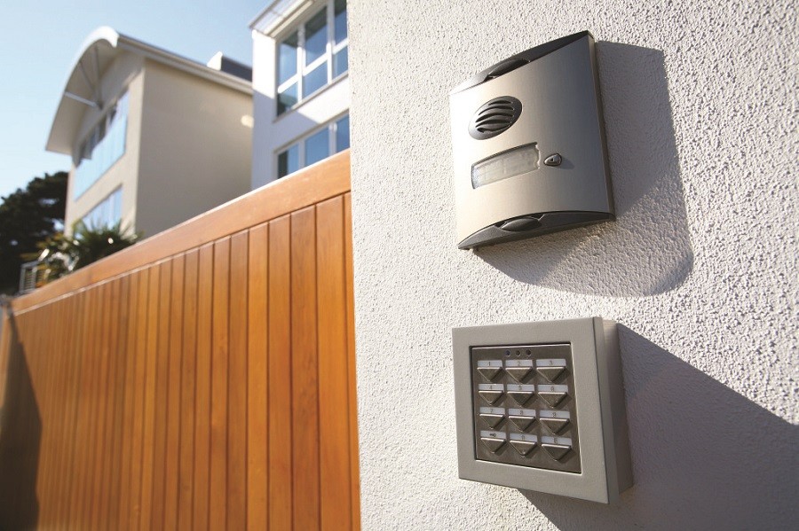 A touchpad and two-way intercom installed outside the gate of a smart home.