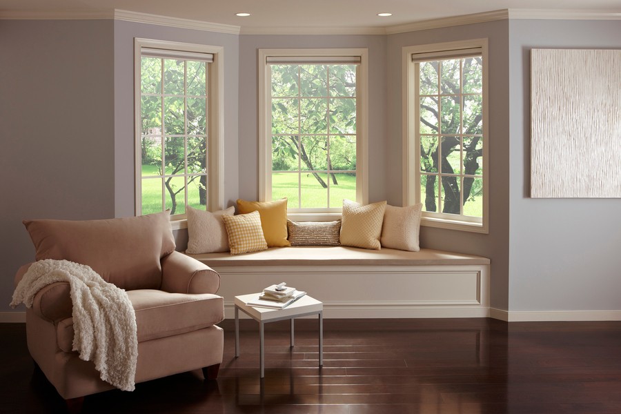 iving room with hardwood floors and a bay window featuring a cushioned window seat and a comfortable armchair.