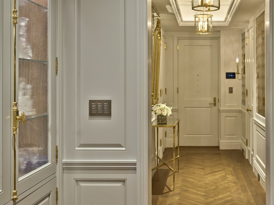 A hallway with elegant lights and a Palladiom keypad.